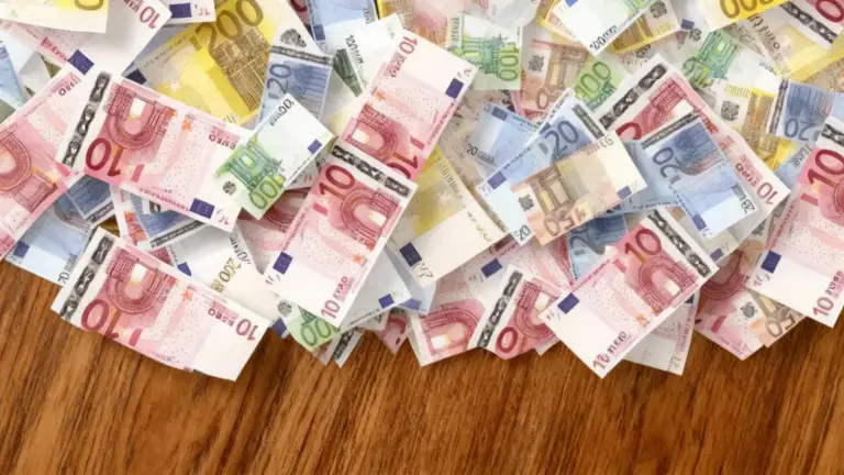 Banconote in euro sparse su una superficie in legno