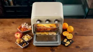Friggitrice ad aria con frutta essiccata su un tavolo di legno