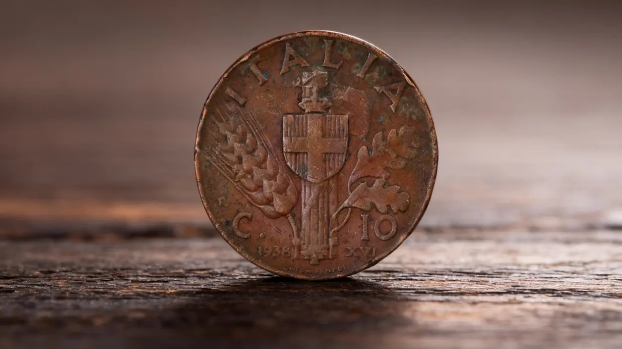 Moneta da 10 centesimi italiana con spiga, datata 1938, su sfondo in legno
