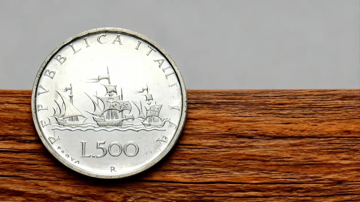 Una moneta da 500 lire italiane poggiata su una superficie in legno