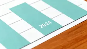 Grafico con una barra evidenziata per l'anno 2024 su sfondo di legno