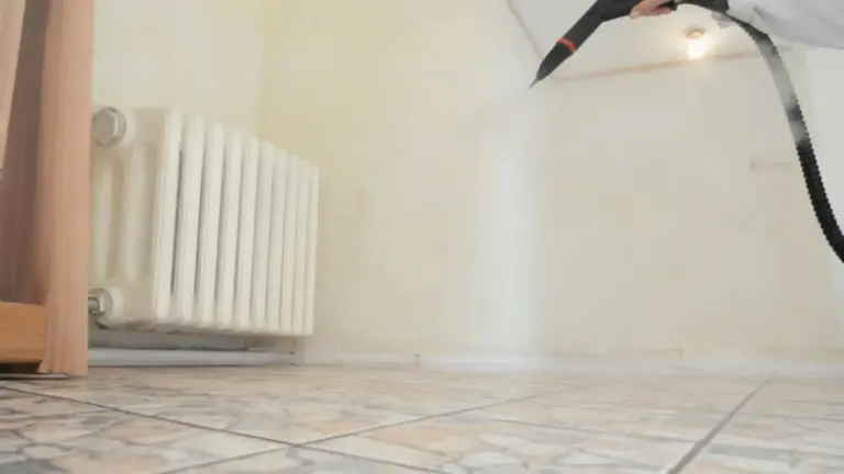 Pulizia con vapore nella parte inferiore nascosta di un radiatore domestico