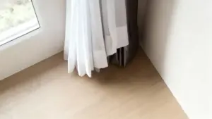 Tende bianche e grigie appena lavate appese vicino a una finestra