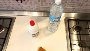 Bottiglia d'acqua e flacone di ammoniaca su un piano cucina vicino ai fornelli