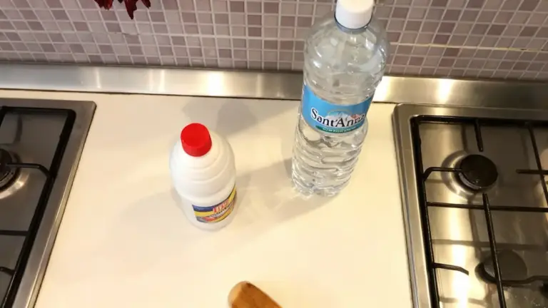 Bottiglia d'acqua e flacone di ammoniaca su un piano cucina vicino ai fornelli
