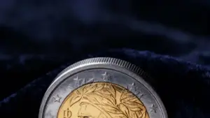 Moneta da 2 euro parzialmente visibile su sfondo scuro