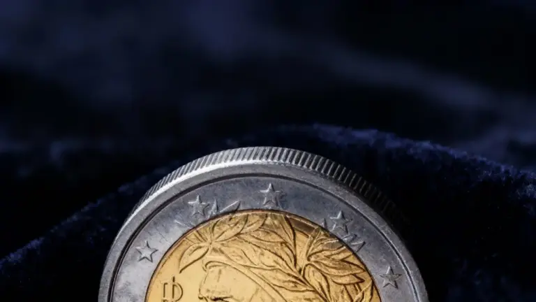 Moneta da 2 euro parzialmente visibile su sfondo scuro