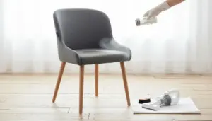 Sedia imbottita grigia mentre viene pulita con metodo a secco su pavimento in legno chiaro