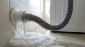 Schiuma che fuoriesce dal tubo di scarico di una lavatrice