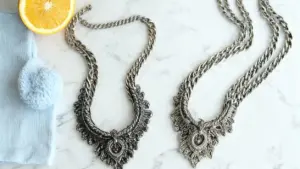 Due collane d'argento, una annerita e una lucidata, su superficie di marmo con limone e panno