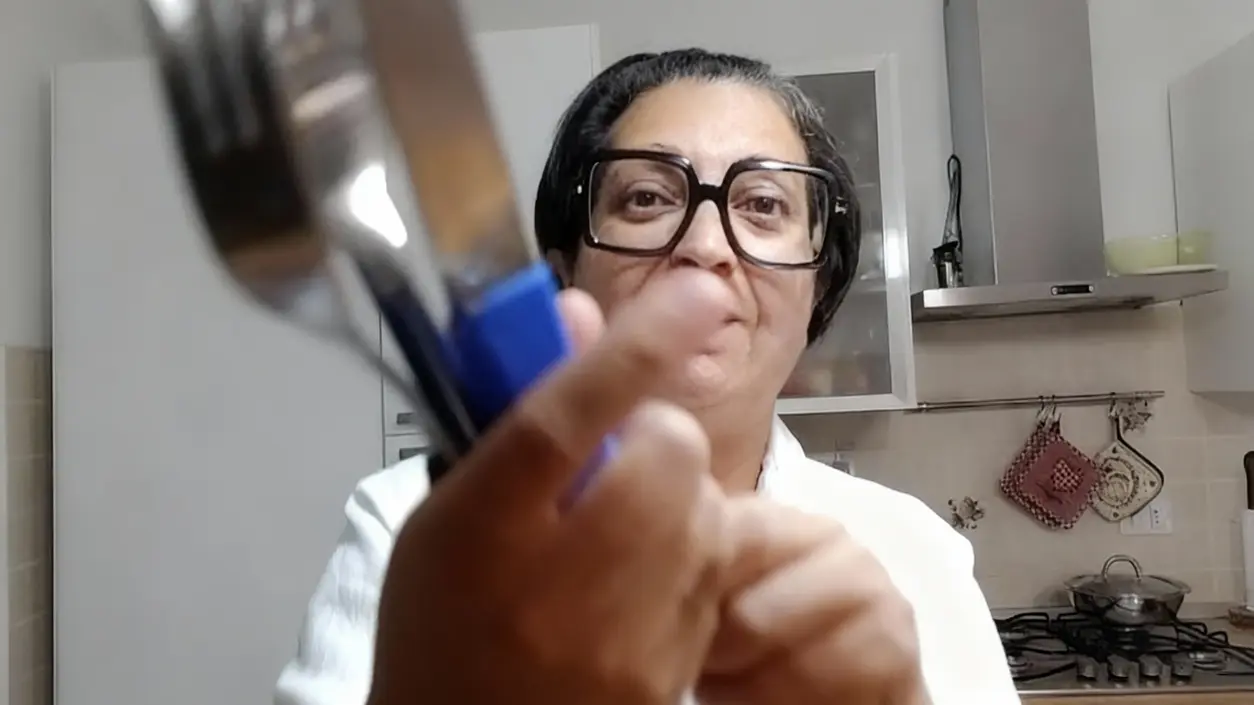 Persona in cucina mostra delle posate di metallo opache o rovinate