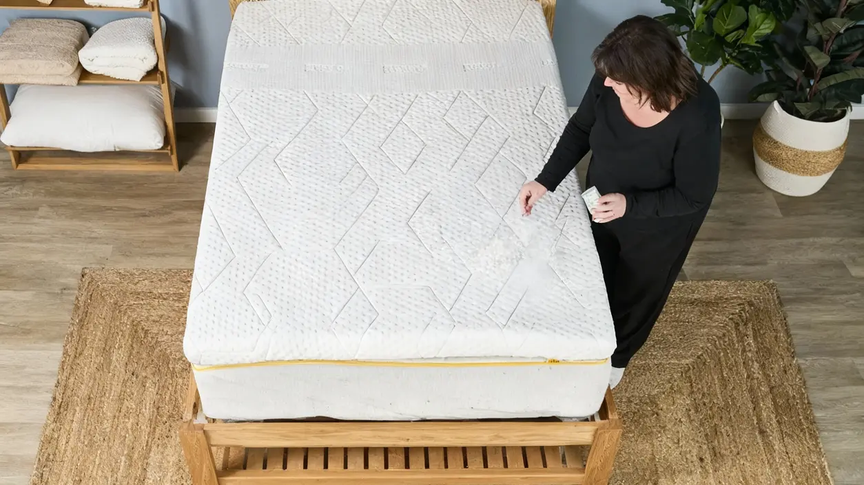 Persona cosparge un ingrediente sul materasso per eliminarne odori e aloni